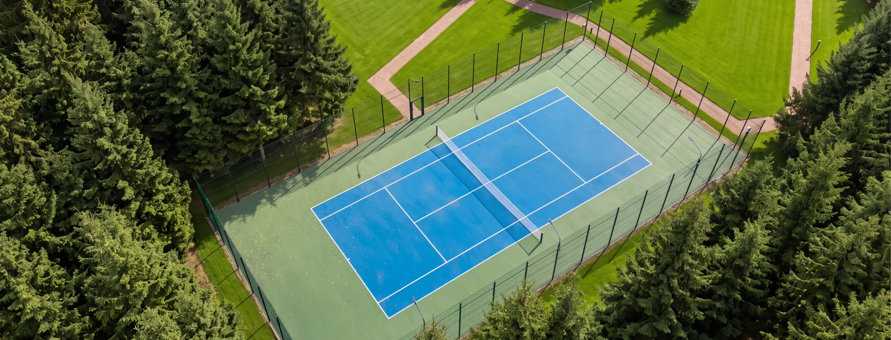 Теннисный корт поселка Woodside Residence с высоты, вокруг хвойный лес